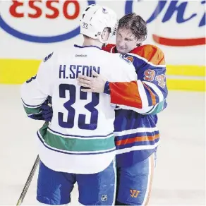 ?? GREG SOUTHAM/FILES ?? Retiring Edmonton Oiler Ryan Smyth gets a hug from Vancouver Canucks captain Henrik Sedin after his final game April 12, 2014 at Rexall Place. The Sedin brothers play their final game tonight against the Oilers at Rogers Place.