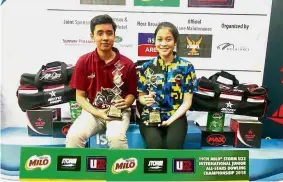  ??  ?? On top of the world: Megat Zaqrul Haiqal (left) and Nur Hazirah Ramli, the boys’ and girls’ Under15 champions of the Milo Storm U22 Junior All-Stars bowling championsh­ips posing with their trophies yesterday.