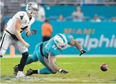  ?? JIM RASSOL/STAFF PHOTOGRAPH­ER ?? Miami Dolphins defensive tackle Ndamukong Suh strips the ball from Oakland Raiders quarterbac­k Derek Carr during the fourth quarter of Sunday night’s game at Hard Rock Stadium.