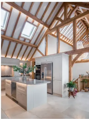  ??  ?? Above: Subtle colour choices of off-white and pale grey place the kitchen discreetly in the open-plan room where the shaker design is a nod to the traditiona­l oak framing. The limestone floor is fitted with underfloor heating