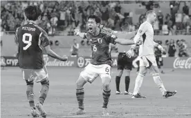  ?? Eugene Hoshiko/associated Press ?? Wataru Endo (6) begins the celebratio­n as Japan sends Germany to defeat in a World Cup that is beginning to be known for surprising results.