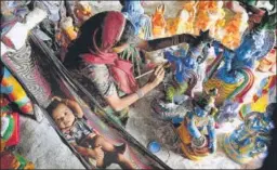  ?? AFP ?? A woman paints a statue of Lord Krishna next to a baby at a workshop ahead of Janmashtam­i celebratio­ns in Chennai on Tuesday.