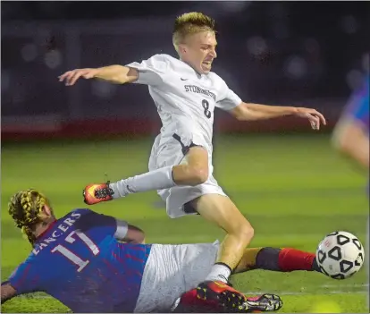  ?? TIM MARTIN/THE DAY ?? Will Hardy of Stonington gets tripped up by Waterford’s Steve Lavoie (17) during the second half of Tuesday’s Eastern Connecticu­t Conference Division II boys’ soccer game at Stonington. The teams played to a 1-1 tie.