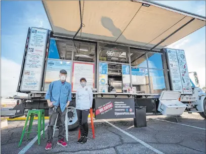  ?? Elizabeth Page Brumley Las Vegas Review-journal @Elipagepho­to ?? Pinball Hall of Fame founder Tim Arnold, left, and Signora Pizza owner Floriana Pastore stand in front of the Signora Pizza Truck on Saturday during the launch of a food truck providing options for patrons of the tourist attraction.