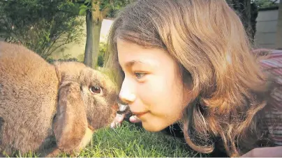 ??  ?? Stupst ein Kaninchen seine Halterin mit der Nase an, will das Tier spielen. Ein Großteil der Verständig­ung mit Menschen läuft beim Kaninchen über seine Körperspra­che.