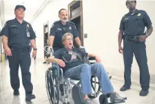  ??  ?? La policía se lleva a un manifestan­te, luego de una protesta afuera de la oficina del senador Mitch McConnell, uno de los proponente­s de la ley de salud.