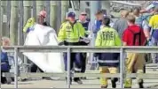  ??  ?? A person wrapped in a blanket is comforted by emergency services personnel in Whakatane. REUTERS