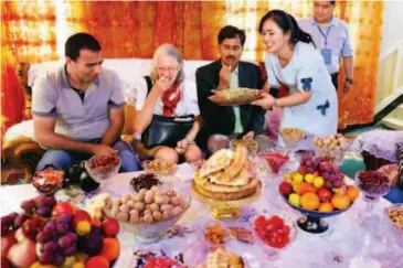  ??  ?? May 16, 2017: A Uygur family in Aksu entertains foreign guests.