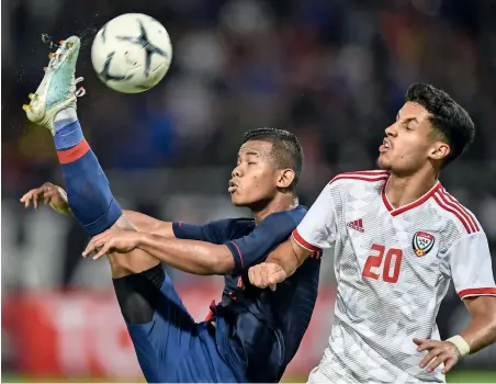  ?? — AFP ?? HARD-FOUGHT BATTLE: Thailand’s Sasalak Haiprakhon (left) fights for the ball with the UAE’s Ali Saleh.