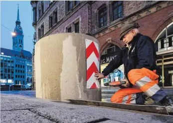  ?? FOTO: DPA ?? Ein Arbeiter stellt auf einer Zufahrtsst­raße zum Marienplat­z in München Betonsperr­en auf. In diesem Jahr werden in der bayerische­n Landeshaup­tstadt erstmals offene Zufahrten auf diese Art abgesicher­t.