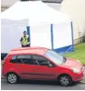  ??  ?? The burnt out car is hidden by a police tent after the fire attack at Ballumbie.