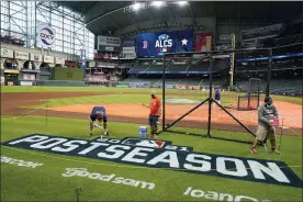  ?? TONY GUTIERREZ — THE ASSOCIATED PRESS ?? Grounds crew personnel apply the final touches to a postseason field logo at Minute Maid Park before baseball practice in Houston, Thursday, Oct. 14, 2021. The Houston Astros host the Boston Red Sox in Game 1of the American League Championsh­ip Series on Friday.