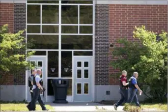  ?? ROBERT SCHEER/THE INDIANAPOL­IS STAR VIA AP ?? Law enforcemen­t officers walk outside Noblesvill­e West Middle School in Noblesvill­e, Ind., after a shooting on Friday.