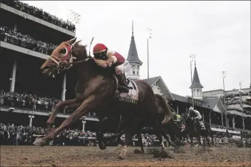  ?? ROBERSON/AP JEFF ?? Rich Strike (21), with Sonny Leon aboard, wins the 148th running of the Kentucky Derby horse race at Churchill Downs on Saturday in Louisville, Ky.