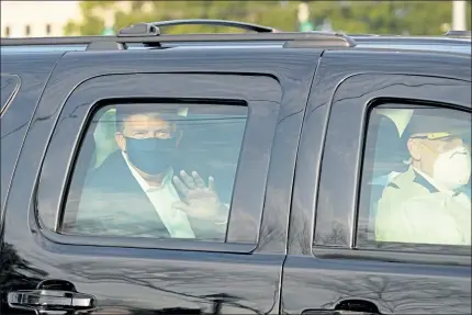  ?? GETTY IMAGES ?? President Trump waves from the back of a car in a motorcade outside of Walter Reed Medical Center in Bethesda, Md., on Sunday.