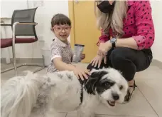  ?? Antonie Robertson / The National ?? Pupil Hind Algaith, 6, has fun with well-being dog Ziggy at Kent College Dubai
