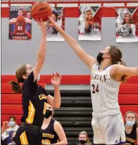  ??  ?? Clarkston’s Madison Skorupski puts up a shot in the lane against the outstretch­ed arm of Birmingham Marian’s Shannon Kennedy (24) in a Division 1 game on Monday.