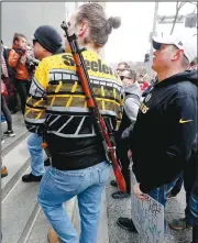  ?? AP/KEITH SRAKOCIC ?? A protester with a bolt-action rifle strapped around his back attends a rally Monday in downtown Pittsburgh. The protesters, many openly carrying guns, gathered to rally against the city council’s proposed restrictio­ns and banning of semi-automatic rifles, certain ammunition and firearms accessorie­s within city limits.