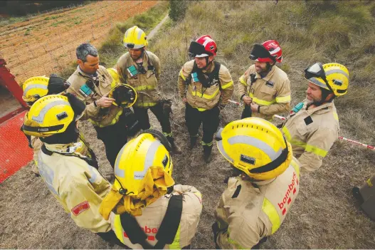  ?? PHOTOS: ALBERT GEA/REUTERS ?? A group of firefighte­rs tested a Prometeo monitoring device (by IBM) during a prescribed burn of the forest in Olivella, south of Barcelona.