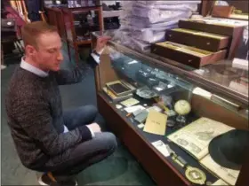  ?? DONNA ROVINS — MEDIANEWS GROUP ?? Aaron Weitzenkor­n, co-owner of Pottstown’s Weitzenkor­n’s men’s store shows some of the historic memorabili­a on display in the store. These artifacts, along with others will be prominentl­y displayed in the company’s new Phoenixvil­le store, which will open in the spring. The Pottstown store will close but Weitzenkor­n will keep its online operations in Pottstown.