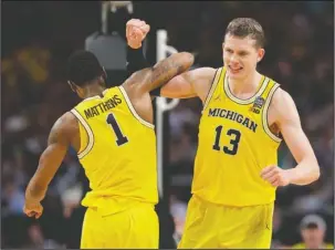  ?? The Associated Press ?? WOLVERINES WIN: Michigan junior Moe Wagner (13) celebrates with Charles Matthews (1) during the second half of the Wolverines’ 69-57 win Saturday over Loyola-Chicago in San Antonio in the Final Four of the NCAA Tournament.