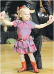  ??  ?? Izzabele, 6, performs her first country dance with her coach and dad, Richard Tymko with the Calgary Dance Stampede.