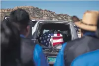  ?? CAYLA NIMMO/GALLUP INDEPENDEN­T FILE PHOTO VIA AP ?? Family members of slain Officer Houston Largo wear blue in his honor and stand by to wait for his casket to be removed from the hearse during funeral services Thursday in Gallup.