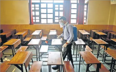  ?? SANCHIT KHANNA/HT PHOTO ?? A classroom at Mount Abu School in Rohini being sanitised, a day before schools in Delhi resume in-person sessions for students of classes 10 and 12.