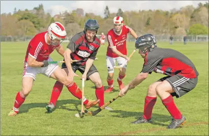  ??  ?? Kinlochshi­el’s Finlay MacRae battles for the ball with Oban Camanachd’s David Lafferty and Craig MacDougall during last Saturday’s Marine Harvest Premiershi­p match which was transferre­d to Inverness. The game ended in a 2-2 draw.