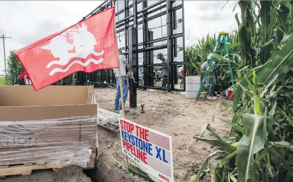  ?? NATI HARNIK/AP ?? The Cowboy Indian Alliance flag, representi­ng a group of ranchers, farmers and tribal communitie­s opposing the Keystone XL pipeline, flies in a cornfield along the path of the proposed project that has been beset with opposition. TransCanad­a says the...