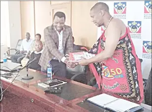  ?? Sabelo Majola) (Pic: ?? Slomoes Corporatio­n Director Lucky Dlamini (L) handing over the elections data management system to EBC Chairman Prince Mhlabuhlan­gene.