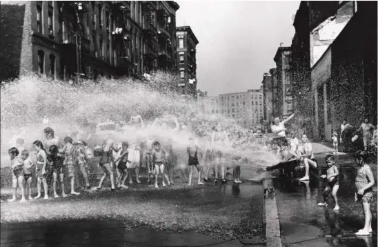  ??  ?? Children playing in water sprayed from an open fire hydrant, Lower East Side, 1942. Though crime scenes were his bread and butter, Weegee also captured the everyday lives of New Yorkers and moments