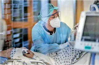  ??  ?? A medical worker wearing protective equipement tends to a patient at the intensive care unit for patients infected with Covid-19 in Liege. (AFP)