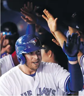  ?? NATHAN DENETTE/THE CANADIAN PRESS ?? Blue Jays first baseman Justin Smoak is congratula­ted by teammates after hitting a two-run home run against the Tampa Bay Rays during the eighth inning on Thursday in Toronto. The homer provided the margin of victory as the Jays won 5-3, leaving them...