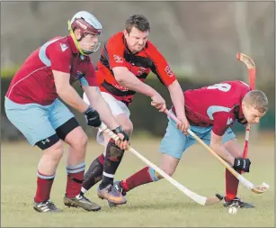  ??  ?? Glenurquha­rt’s David MacLennan goes between Strathglas­s players Michael Stokes and Lewis Douglas.