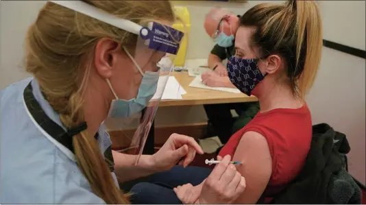  ?? Photo: AFP ?? A health worker receives her COVID-19 vaccine along with other social care workers at the Internatio­nal Centre for Life in Newcastle upon Tyne, northeast England, on Saturday.