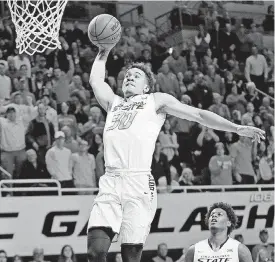  ?? [PHOTO BY NATE BILLINGS, THE OKLAHOMAN] ?? Jeffrey Carroll, left, gets ready to dunk the ball during Oklahoma State’s recent game against Texas Tech at Gallagher-Iba Arena. OSU is locked into the No. 5 seed for next week’s Big 12 Tournament in Kansas City, Mo.