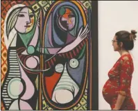  ?? The Associated Press ?? LOVE, FAME, TRAGEDY: A woman looking at Pablo Picasso's Girl before a Mirror, 1932, during a preview of the exhibition Picasso 1932 - Love, Fame, Tragedy on Tuesday at Tate Modern in London. The first ever solo Pablo Picasso exhibition remains at Tate...