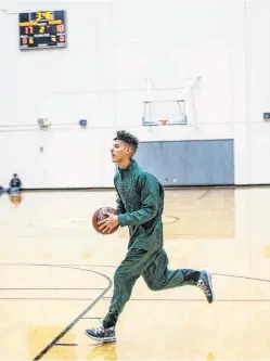  ?? Matthew Busch / Contributo­r ?? Reagan senior Kaeyel Moore runs warmup drills before the Rattlers’ game with Marshall, his first on the court since he suffered cardiac arrest and collapsed during a practice in January because of a heart ailment. “It’s a miracle if you think about it,” coach John Hirst said of Moore’s return. Moore, a senior, played briefly in Monday’s game, the team’s first of the season.