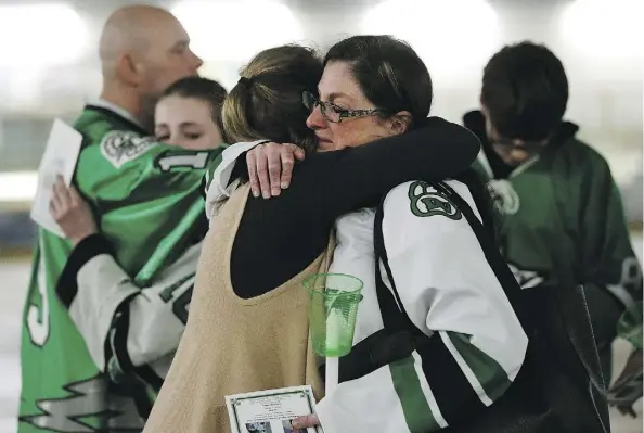  ?? LARRY WONG ?? Cory Anne Holmlund, right, gets a hug Tuesday night during a vigil held in Drayton Valley to honour three Humboldt Broncos who once lived in the town, two of whom died in the fatal bus crash Friday night. Holmlund’s family billeted Parker Tobin when he...