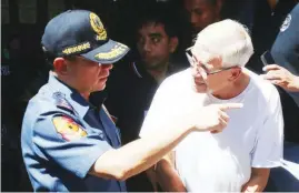  ?? (Ali Vicoy) ?? By MARTIN SADONGDONG NATIONAL Capital Region Police Office (NCRPO) chief Director Guillermo Eleazar (left) serves warrant of arrest against Father Kenneth Bernanard Pius Hendricks, an American priest accused of molesting at least 50 boys.
