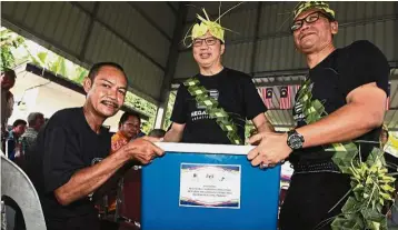  ??  ?? For a good cause: Liow and Bentong Municipal Council president Datuk Mohd Shahid Ismail (right) presenting food aid to Rahim Utah (left) at Kampung orang asli Cinta Manis to celebrate Merdeka in Karak.