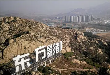  ?? BLOOMBERG ?? China’s answer to the Hollywood sign stands on a hill above Dalian Wanda Oriental Movie Metropolis’ film production hub in Qingdao, China.