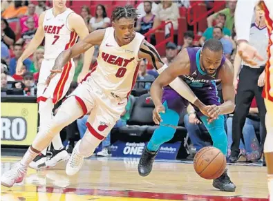  ?? JOHN MCCALL/SUN SENTINEL ?? Heat guard Josh Richardson and Hornets guard Kemba Walker chase the ball in the second half Sunday at American Airlines Arena.