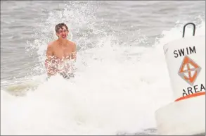  ?? Christian Abraham / Hearst Connecticu­t Media ?? Fairfield youth Eric (last name not given) braces himself against a crashing wave as he and two other buddies play in the surf at Jennings Beach in Fairfield on Friday.