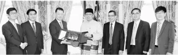  ??  ?? Choi (third left) hands over a memento to Abang Johari. — Penerangan Photo