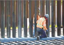  ?? Sandy Huffaker / Getty Images ?? Constructi­on workers build a secondary border wall on Friday in Otay Mesa, Calif., south of San Diego.