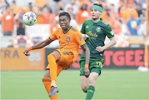  ?? AP Photo/michael Wyke ?? Houston Dynamo defender Teenage Hadebe, left, brings down the ball in front of Portland Timbers forward Jarosław Niezgoda (11) April 16 during the second half of an MLS soccer match in Houston.