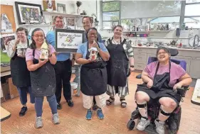  ?? PHOTOS PROVIDED BY GOODWILL MANASOTA ?? Coming together on World Autism Awareness Day were Goodwill Manasota president Donn Githens and Easterseal­s Southwest Florida president Tom Waters (holding sign) with Art Initiative Program participan­ts, from left, Denise, Ana, Patty, Shannon and Julie.