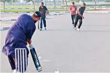  ?? — AFP photo ?? Expatriate workers play cricket on a parking lot in Dubai.